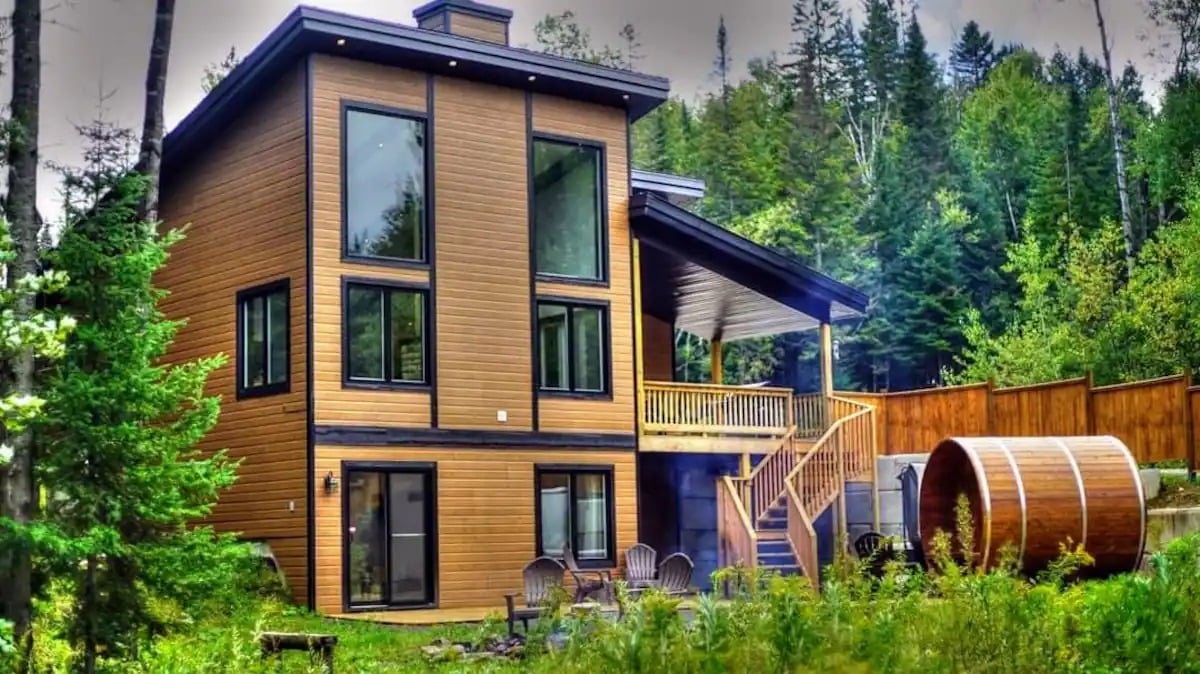 Le Naturo Sauna et Spa cottage surrounded by lush summer greenery in Lanaudiere